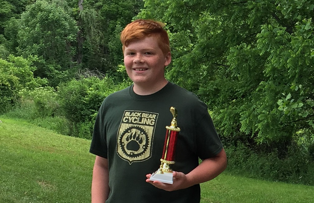 Teenage boy holds trophy